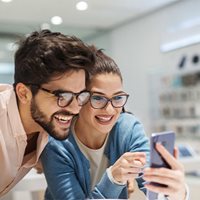 Vision Savings - Couple wearing glasses looking at phone