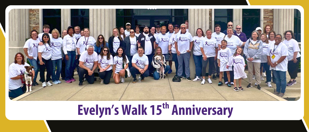 2025 Evelyn's Walk Event Participants lined up next to the 143rd Orland Park branch with Rolfe t-shirts smiling at camera.